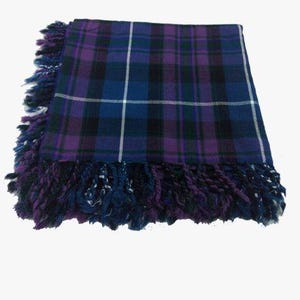 May include: A purple, blue, and white plaid kilt with a fringed edge.