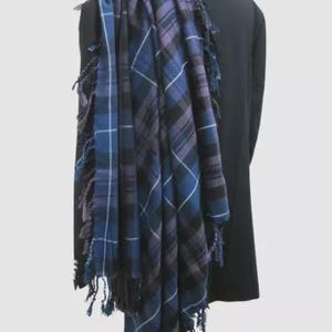May include: A blue and purple plaid kilt with fringed edges draped over a black jacket.
