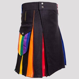 May include: A black utility kilt with a rainbow stripe detail on the side. The kilt has a large cargo pocket with a rainbow stripe flap.
