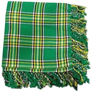 May include: Green, yellow, and white plaid fabric with fringed edges. The fabric has a traditional tartan pattern.