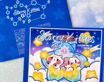 May include: A blue coloring book titled "Starry Kitties" with illustrations by Yinteresting. The cover features two cartoon kittens inside a glass jar with yellow star accents. The book is surrounded by a blue background with stars.