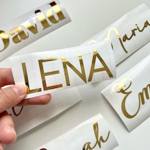May include: Gold vinyl lettering on white sheets. The names "David", "Lena", "Maria", "Emma", and "Sarah" are visible.