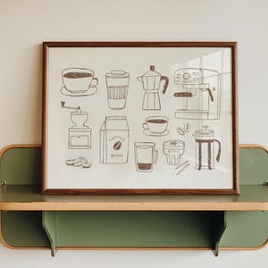 May include: A framed print featuring dark brown line drawings of coffee-related items including a grinder, a bag labeled coffee beans, a French press, an espresso machine, a moka pot, various cups, and coffee beans on a light background.