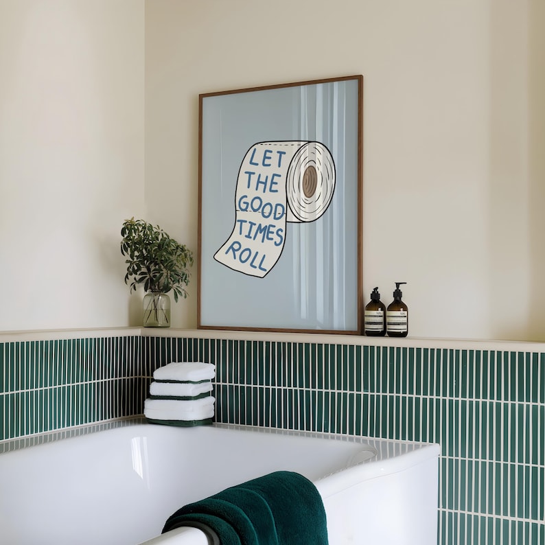 Illustrated toilet paper wall art with the phrase “Let the Good Times Roll” in blue lettering on a soft blue background, designed as playful bathroom decor.
