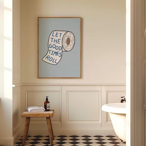 Illustrated toilet paper wall art with the phrase “Let the Good Times Roll” in blue lettering on a soft blue background, designed as playful bathroom decor.