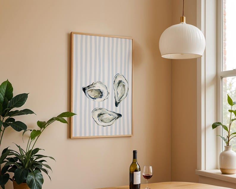oyster print, coastal kitchen decor, watercolor seafood, preppy wall art, a watercolor painting of three oysters on the half shell, artfully arranged on a background of light blue and white vertical stripes, perfect for a beach house or kitchen.