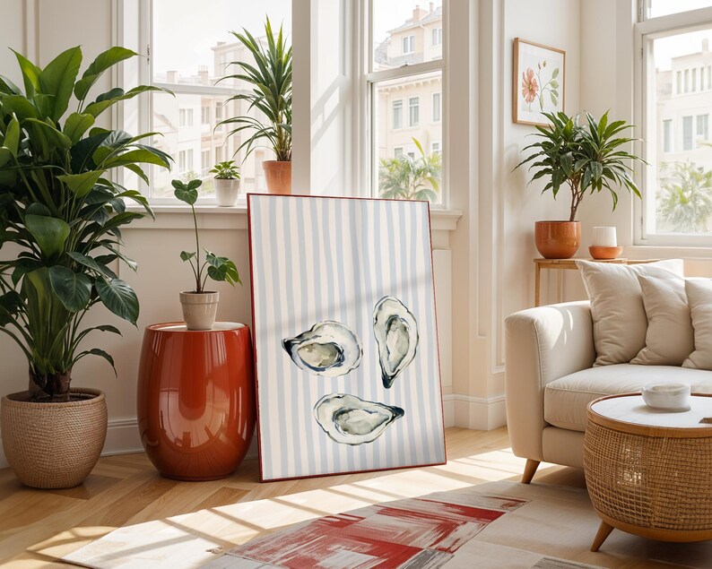 oyster print, coastal kitchen decor, watercolor seafood, preppy wall art, a watercolor painting of three oysters on the half shell, artfully arranged on a background of light blue and white vertical stripes, perfect for a beach house or kitchen.