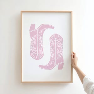 coastal cowgirl decor, pink wall art set, how lucky are we, preppy prints, a gallery wall set of three framed prints in a pink, coastal cowgirl style: one with a bikini on a clothesline, one with the quote 'How lucky are we?' on a striped background, and one with a pair of pink cowboy boots.