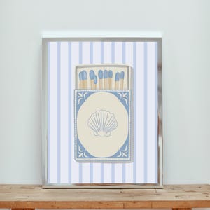 May include: A blue and white striped background with a vintage matchbox illustration. The matchbox has a blue border and a seashell design. The matches inside the box are blue and white.