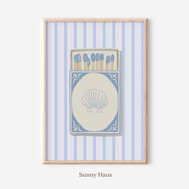 May include: A blue and white matchbox with a seashell design. The matchbox is filled with matches with blue tips. The matchbox is on a light blue and white striped background.
