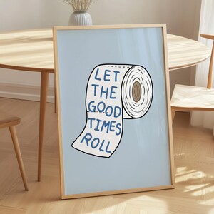 Illustrated toilet paper wall art with the phrase “Let the Good Times Roll” in blue lettering on a soft blue background, designed as playful bathroom decor.
