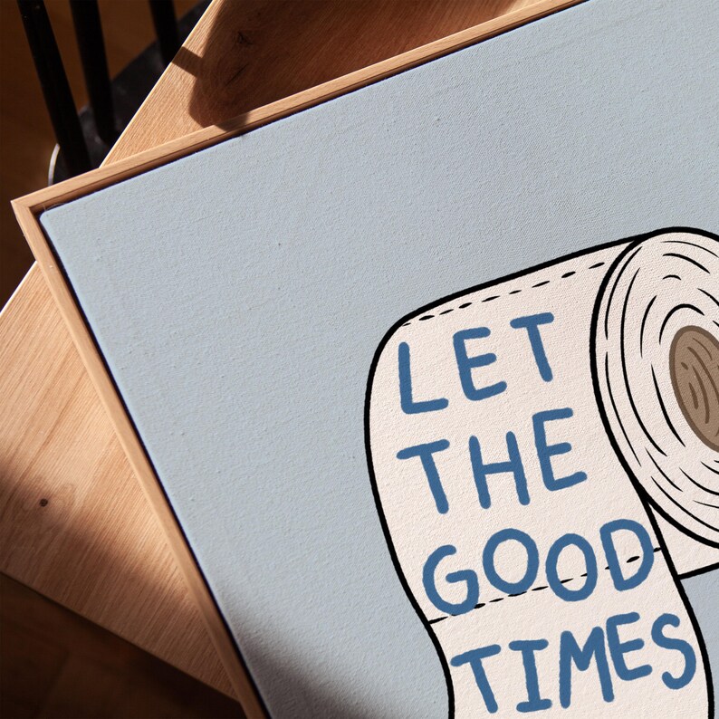 Illustrated toilet paper wall art with the phrase “Let the Good Times Roll” in blue lettering on a soft blue background, designed as playful bathroom decor.