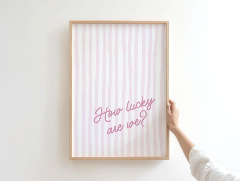 coastal cowgirl decor, pink wall art set, how lucky are we, preppy prints, a gallery wall set of three framed prints in a pink, coastal cowgirl style: one with a bikini on a clothesline, one with the quote 'How lucky are we?' on a striped background, and one with a pair of pink cowboy boots.