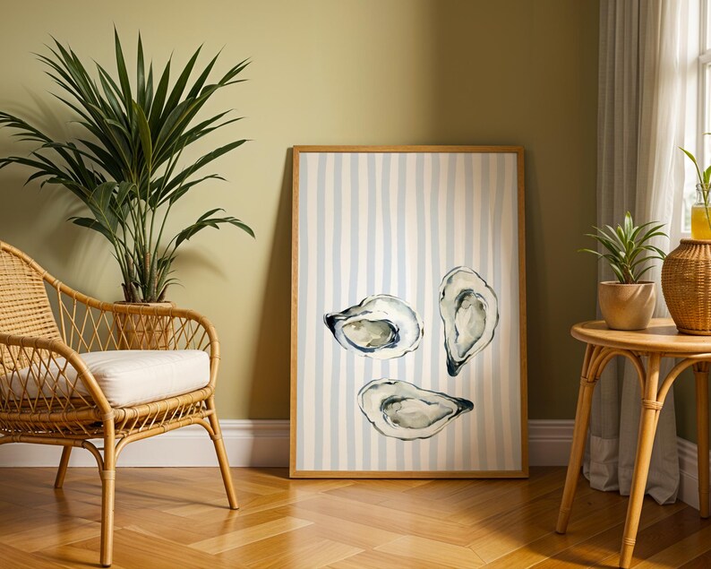 oyster print, coastal kitchen decor, watercolor seafood, preppy wall art, a watercolor painting of three oysters on the half shell, artfully arranged on a background of light blue and white vertical stripes, perfect for a beach house or kitchen.