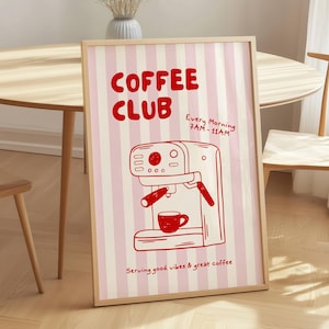 Op de afbeelding: Een ingelijste poster met een roze en witte gestreepte achtergrond. De poster toont de woorden "COFFEE CLUB" in het rood, samen met een rode illustratie van een espressomachine en een koffiekopje. Tekst op de poster luidt "Every Morning 7AM-11AM" en "Serving good vibes & great coffee."