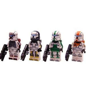Puede incluir: Cuatro minifiguras de Lego de soldados clon en armadura blanca con varios acentos de color. Cada figura sostiene un rifle bláster negro. Los soldados tienen cascos con detalles rojos, negros, verdes y naranjas.