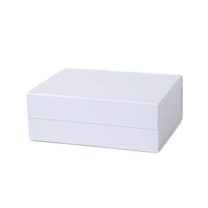May include: A white, rectangular box with a lid. The box is made of a smooth, solid material and has a clean, minimalist design. The box is likely used for storage or packaging.