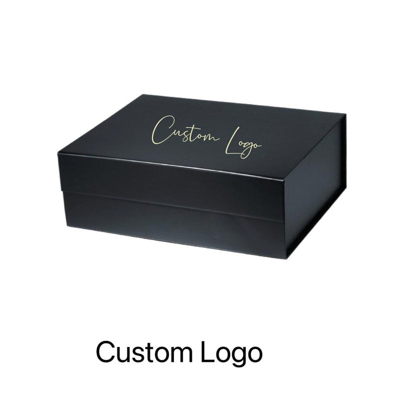 May include: A black rectangular box with a magnetic closure. The box has a gold script font that reads "Custom Logo" on the lid. The box is sitting on a white background.