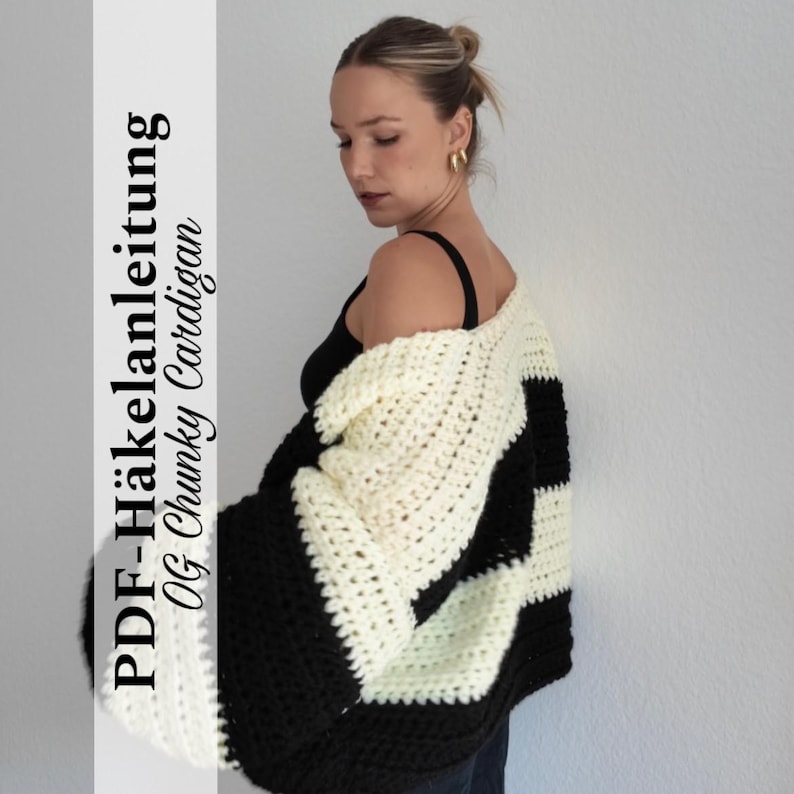Pode incluir: Um cardigan grosso e grande com um design de blocos de cores preto e creme. O tecido de malha grosso apresenta um padr&atilde;o arrojado e &eacute; usado sobre um top preto. A imagem inclui o texto "PDF-H&auml;kelanleitung OG Chunky Cardigan."