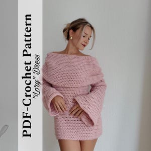 May include: A light pink, off-the-shoulder crochet dress with long, flared sleeves. The dress is a mini-dress style and is handmade. Text on the left side reads "PDF-Crochet Pattern 'Lory' Dress". The dress is worn by a person.