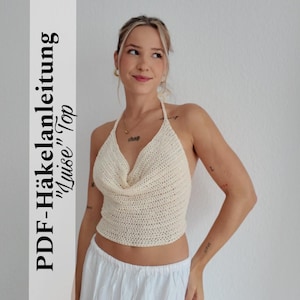May include: Cream-colored, halter-style crochet top. The top features a cowl neckline and is made of a textured, knitted material. The image includes text that reads "PDF-Häkelanleitung 'Luise' Top".