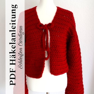 Könnte beinhalten: Ein roter Häkelcardigan mit einer Binde-Verschluss. Der Text "PDF Häkelanleitung Schleifen Cardigan" ist auf der linken Seite des Bildes sichtbar.