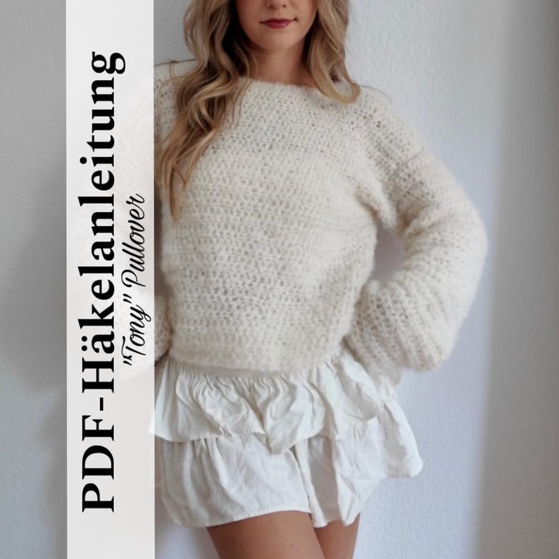 May include: Cream-colored, hand-crocheted pullover sweater with long sleeves. The sweater has a textured stitch pattern and a round neckline. The image also shows a white ruffled skirt. Text on the left side reads "PDF-H&auml;kelanleitung 'Tony' Pullover".