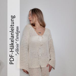 Könnte beinhalten: Cremefarbene Häkeljacke und passende Hose. Die Jacke hat einen V-Ausschnitt und einen Bindverschluss. Der Text auf der linken Seite des Bildes lautet "PDF-Häkelanleitung 'Alicia' Cardigan". Das Outfit ist aus leichtem, offen gewebtem Material.