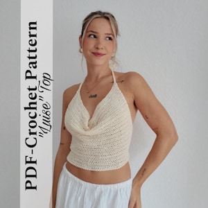 May include: A cream-coloured crochet halter top with a cowl neckline. The top is handmade and features a textured stitch pattern. Text on the left side reads "PDF-Crochet Pattern 'Luise' Top". A stylish and unique garment.