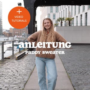 May include: A woman wearing a brown knitted sweater and blue jeans stands in front of a brick wall. The text "anleitung" and "Paddy Sweater" is written in white letters on a black background.