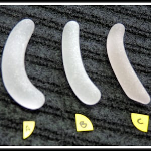 May include: Three white, curved, smooth, glass pieces labeled A, B, and C. The pieces are arranged in a row from left to right.