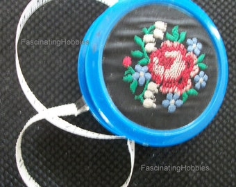 Vintage - ROLLUP CELLULOID TAPE- Fabric Rose & Lily of the Valley Embroidered- back plain  with red button to roll up- very good condition