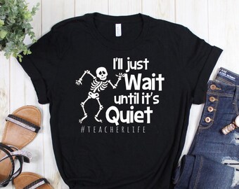 May include: Black t-shirt with a white skeleton dancing and the text "I'll just Wait until it's Quiet #TEACHERLIFE"