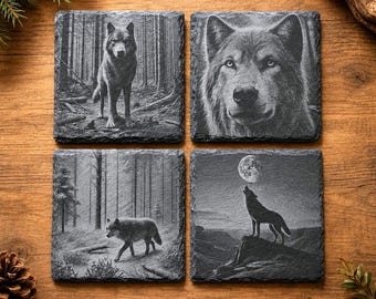 May include: Set of four square slate coasters with engraved wolf designs. Each coaster features a different wolf image: a standing wolf in a forest, a close-up of a wolf's face, a wolf walking in a forest, and a howling wolf under a full moon.