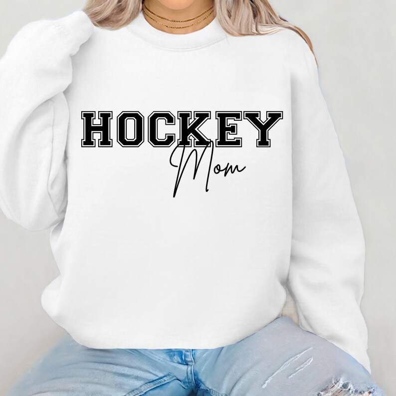 May include: White sweatshirt with black text that reads "HOCKEY Mom" in a varsity style font.