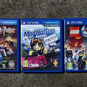 Puede incluir: Tres cajas de juegos para PlayStation Vita que incluyen LEGO Harry Potter Años 5-7, ModNation Racers Road Trip y The LEGO Movie Videogame. Cada caja de plástico azul muestra el título del juego, arte de personajes y un icono verde de edad 7.