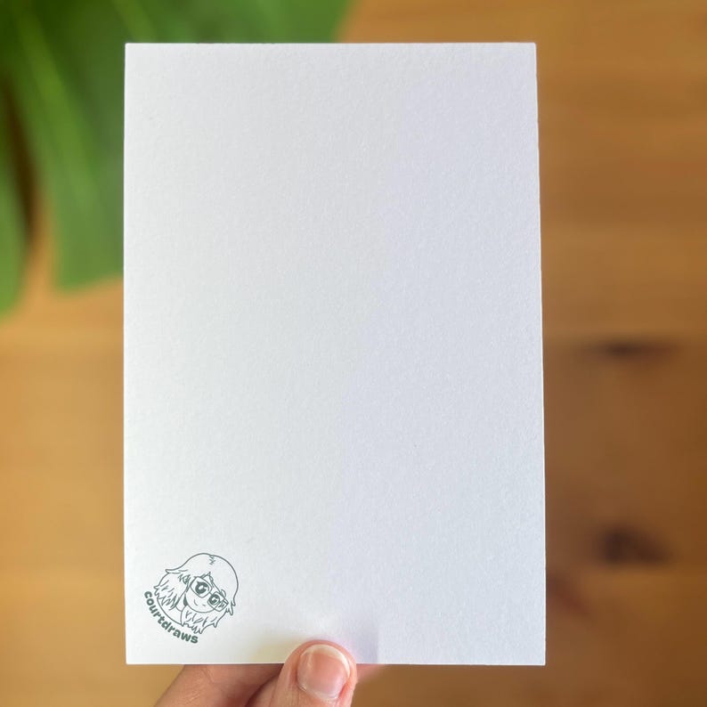 May include: Blank white card with a small, hand-drawn illustration of a person wearing glasses in the bottom left corner. The illustration is in gray and says "court draws" underneath.