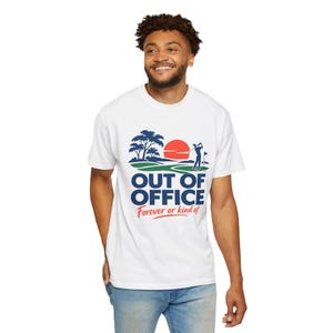 Puede incluir: Una camiseta blanca de manga corta con un gráfico de un golfista en un campo verde con árboles y un sol rojo. El texto dice OUT OF OFFICE en letras azules grandes, con el texto más pequeño en rojo Forever or kind of debajo.