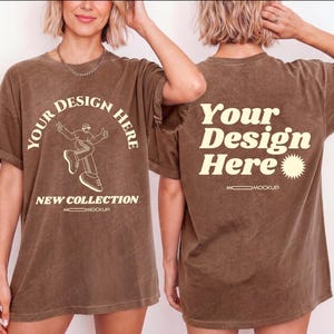 May include: A brown, acid-wash t-shirt featuring cream-colored text and graphics. The front displays the text "YOUR DESIGN HERE" in an arch, a line drawing of a person, and "NEW COLLECTION". The back shows "Your Design Here" and a sun icon.