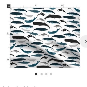 May include: A white fabric with a repeating pattern of blue, black, and gray whales. The fabric is 16 inches by 16 inches.