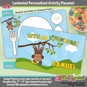 May include: A laminated personalized activity placemat featuring a monkey hanging from a tree branch with the text "Let's Go Bananas!" and the name "Samuel". The back of the placemat has a fork, a cup, and the text "All Set!" The placemat is 17 inches by 11 inches and has rounded corners.