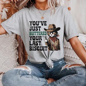 You&#39;ve Just Buttered Your Last Biscuit Tee | Funny Cowboy Cat T-Shirt | Western Outlaw Feline Graphic | Southern Humor Meme Shirt | Sassy