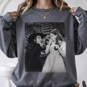 Felpa vintage con immagine tratta dal film "La strega", girocollo con grafica a tema spettrale, abbigliamento accogliente per l'autunno.