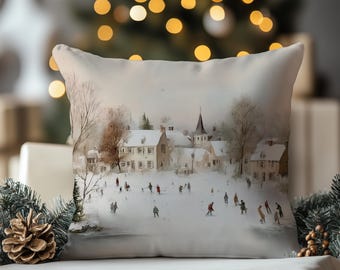 Puede incluir: Un cojín cuadrado con una escena invernal impresa que muestra un pueblo cubierto de nieve con casas y el campanario de una iglesia. El paisaje presenta personas patinando sobre hielo en un estanque congelado, en tonos blancos, grises y marrones.