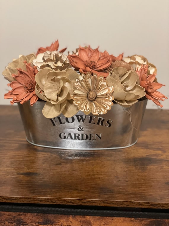 Elegant fall colored Sola Wood flowers arranged in a flowers and garden tin.