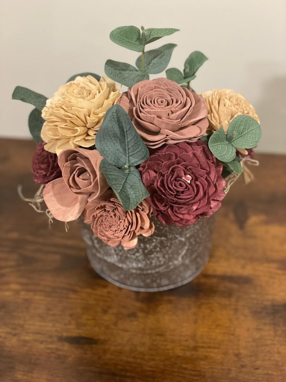 Hand painted Sola wood flowers arranged in a small tin hanging basket.  Perfect for hanging outside in a covered area away from the elements