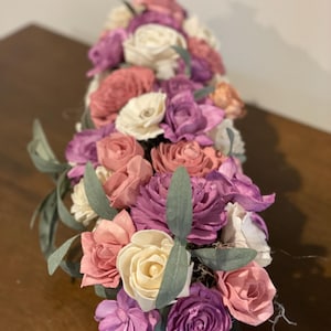 Beautiful sola wood flowers hand painted wood flowers in purple, lavender, mauve and white arranged in a black wooden box.