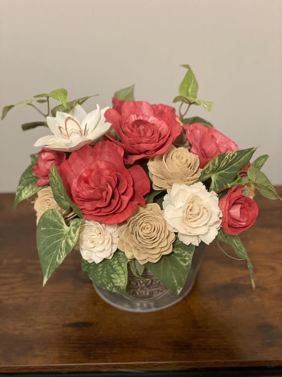 Beautiful burgundy, beige and white hand dyed Sola Wood flowers arranged in a round tin container.