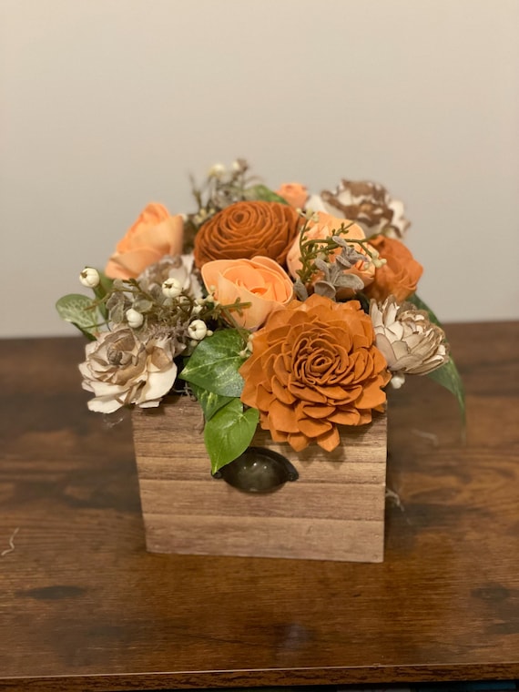 Fall colored Sola Wood flowers arranged in a wooden file box.