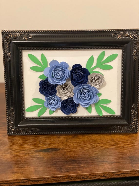 Unique hand rolled paper flower arranged on a 5x7 picture frame.
